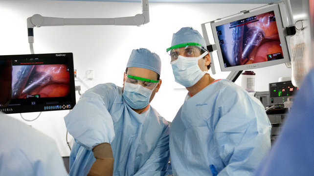 Two surgeons perform a minimally invasive procedure.