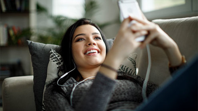 Teenage girl looking at the screen of her phone.