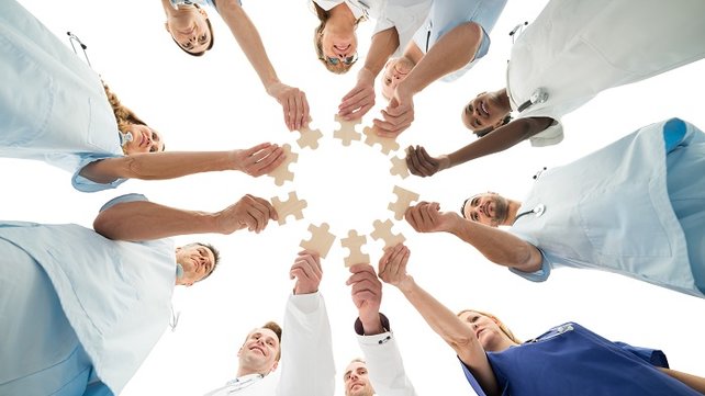 Doctors and medical employees holding jigsaw puzzle pieces