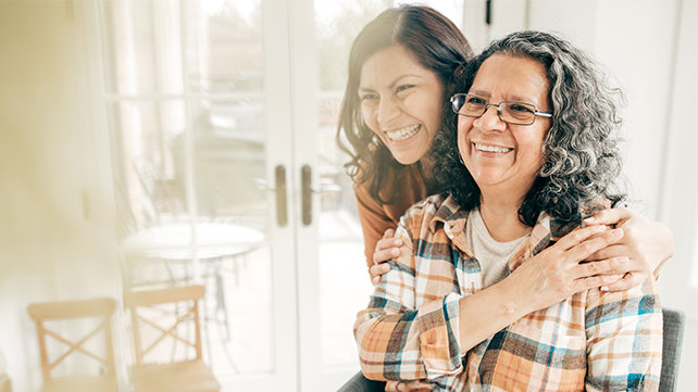 A woman hugs an older female relative.
