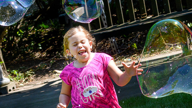Young girl playing with bubbles at Camp Grace.