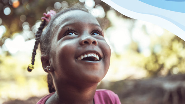 A young girl looks up at the sky.