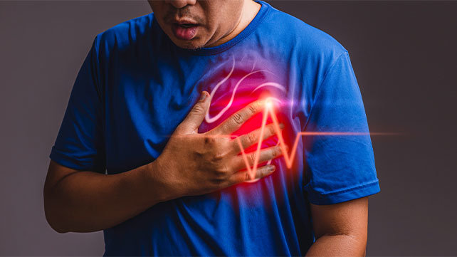 A man puts his hand on pain on the left side of his chest.