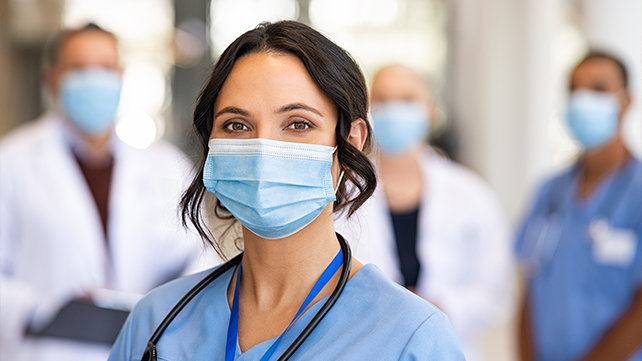 A nurse stands at the front of a medical team