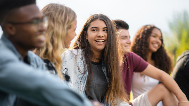 Young adults smiling and talking.