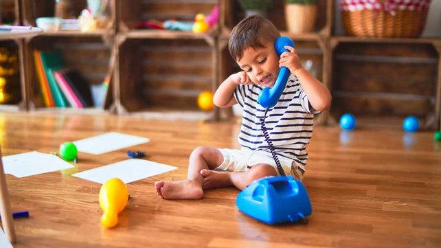 Toddler playing with pretend phone