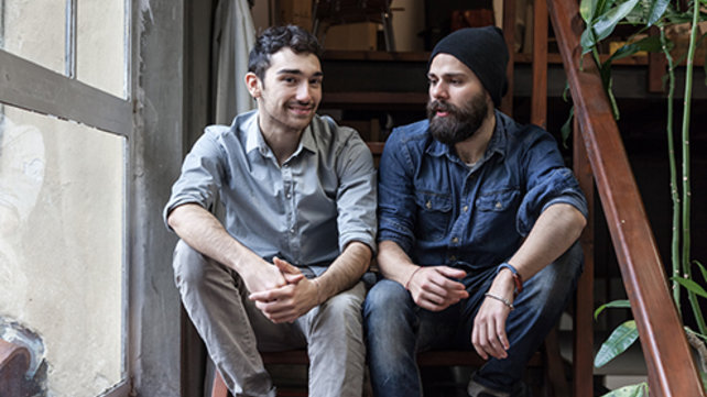 Two adults sitting on stairs and talking