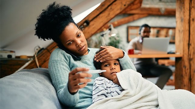 Mother on the phone, while taking temperature of sick child
