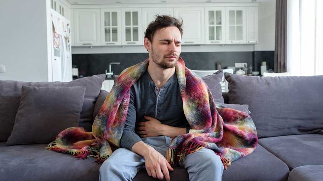 Man on couch with stomach bug
