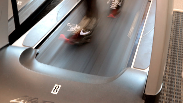Two feet walking fast on a treadmill.