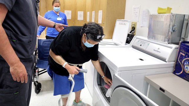 Staff working with a patient to do laundry at Vanderbilt Reahabilitation Center