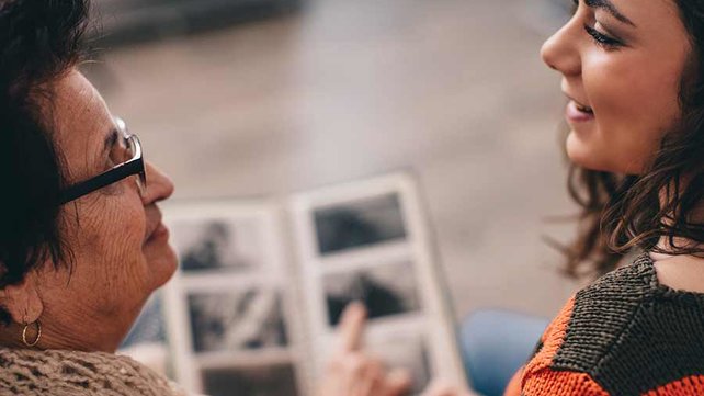 grand mother and daughter looking at photo album