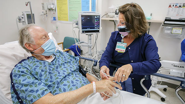 A nurse at The Miriam Hospital caring for an older patient.