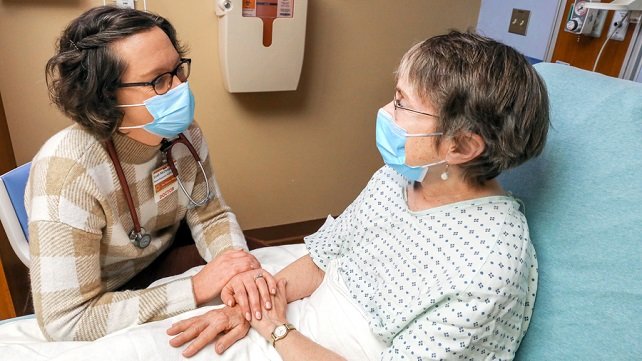 Leah McDonald, MD, a palliative care physician, providing comfort through conversaton with an older female patient in the emergency department at The Miriam Hospital.