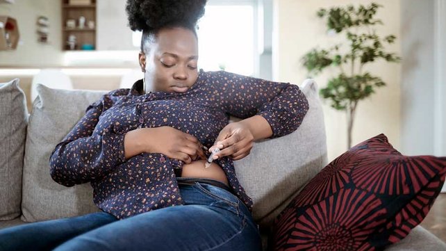 Women giving herself insulin shot