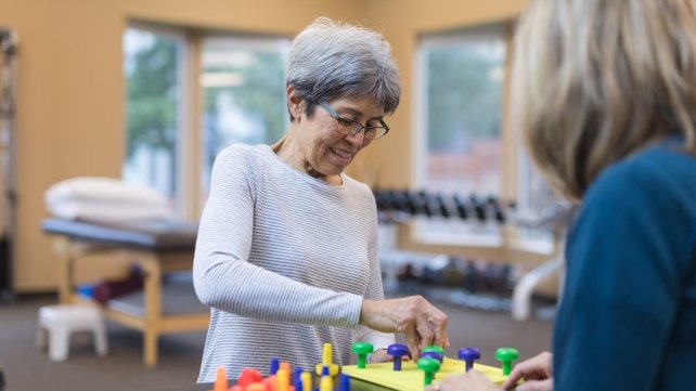 older woman working with an occupational therapist