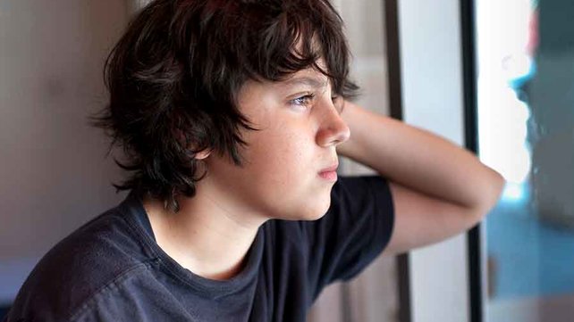Teenager looking out a window
