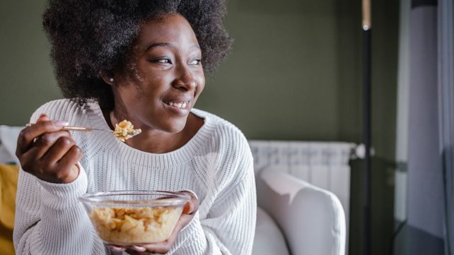 A woman eating cereal and smiling