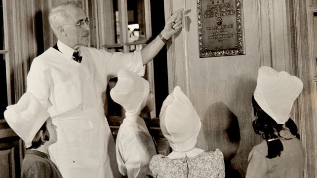Dr. Charbonnel with patients wearing Dutch paper caps to prevent the spread of lice.
