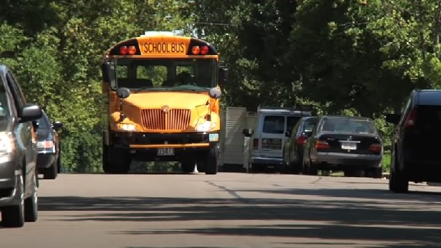 School bus driving down a residential road