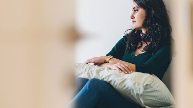 Lonely young adult sitting in bedroom