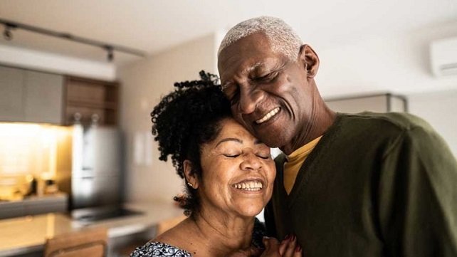 Older couple smiling and leaning into one another