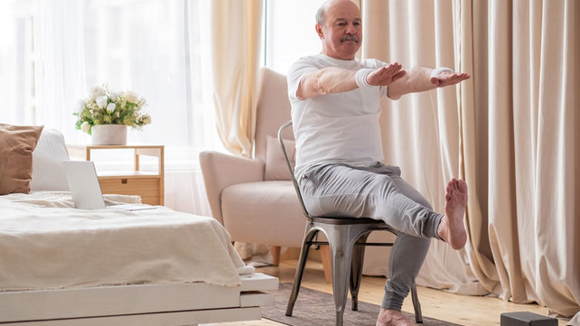 man sitting on chair doing yoga