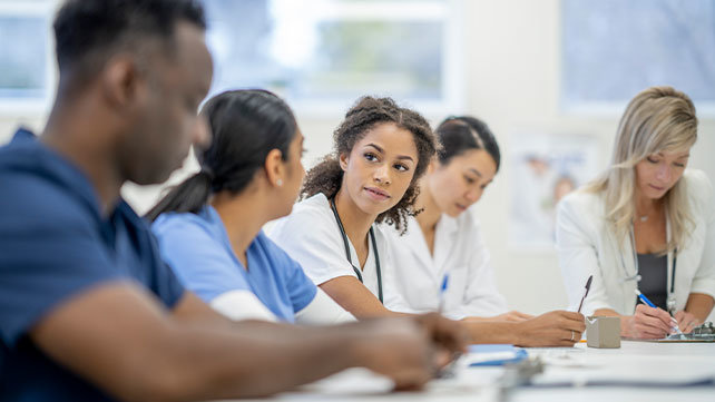 Medical students sitting around a table at a learning seminar