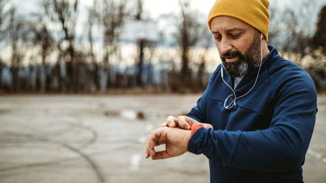 Man checking heart rat eon watch after jogging