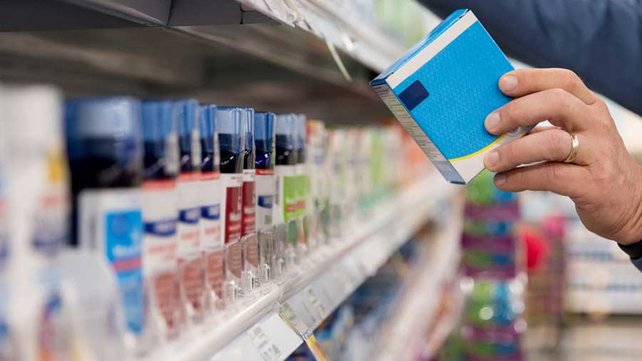 Person looking at ingredients of cold medicine in pharmacy