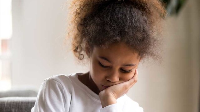 Young girl sitting alone sad