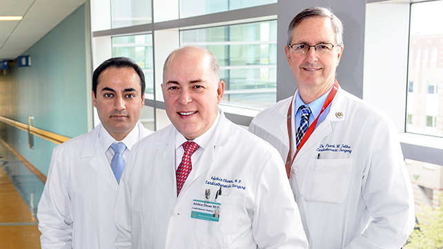 3 cardiovasscular surgeons standing in a hallway.