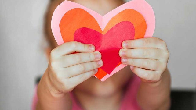 Little girl holding heart cut outs