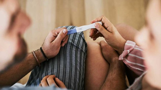 Two people holding pregnancy test