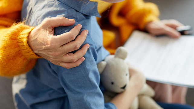 An older adult comorting a child