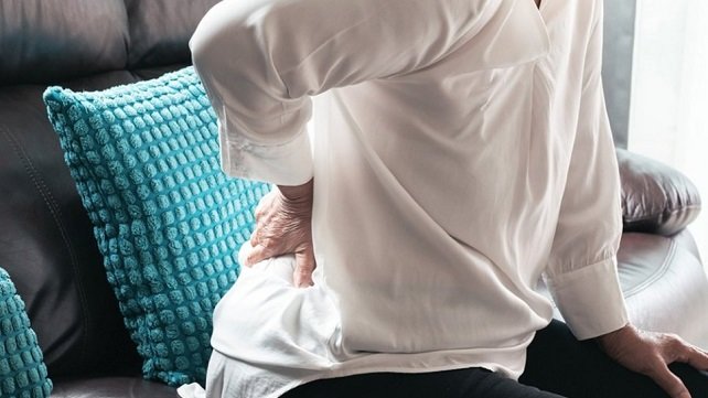 Close up of person holding their lower back