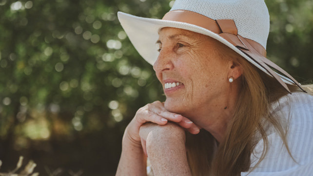 Older woman outside and wearing a sun hat