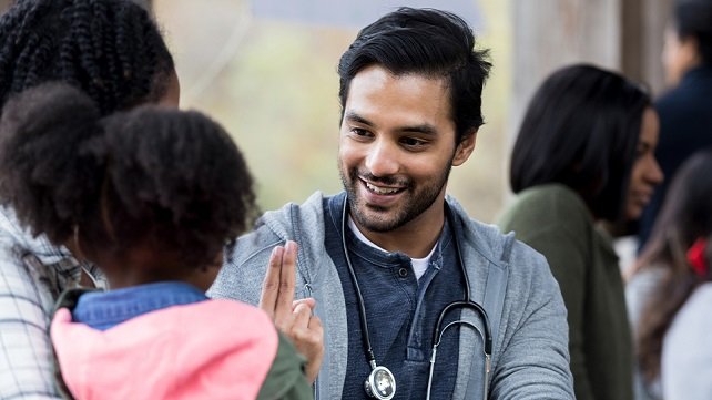 Hospital employee speaking with a woman and her child