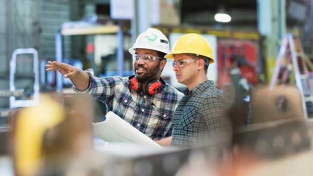 Workers wearing hard hats in a manufacturing center