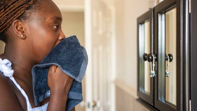 Teenager washing face in mirror