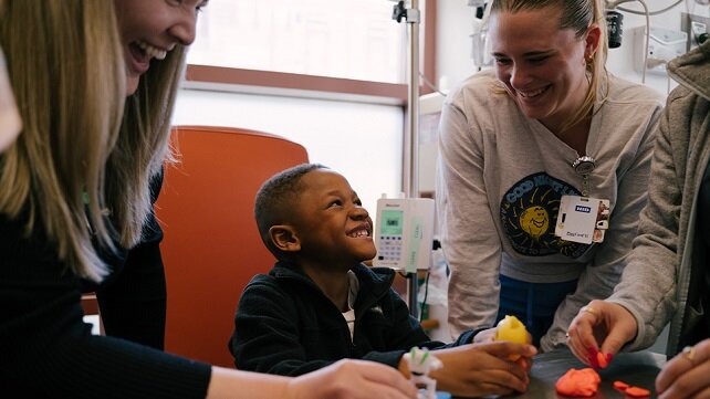 Smiling young boy with two female staff