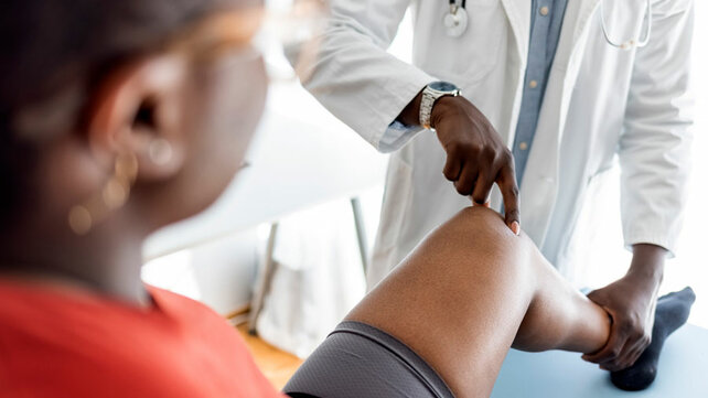 Women getting knee looked at by provider