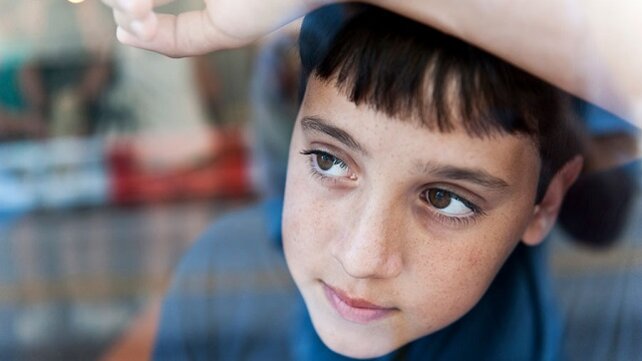 Sad looking boy looking out a window