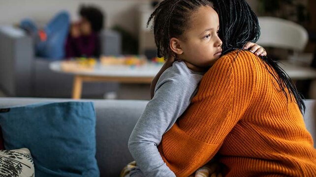 Mother comforting son on couch
