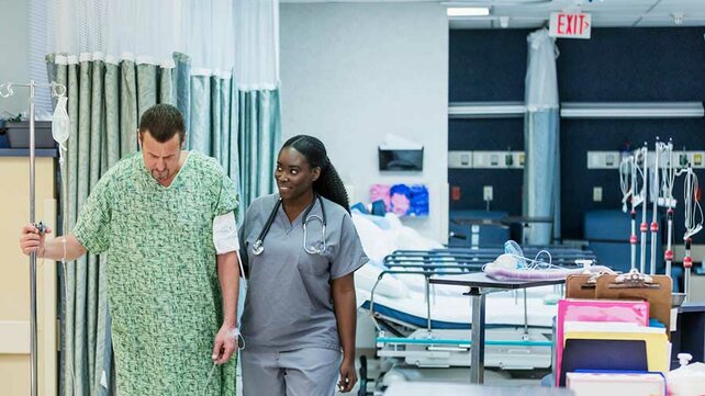 PAtient walking in hospital with health care worker