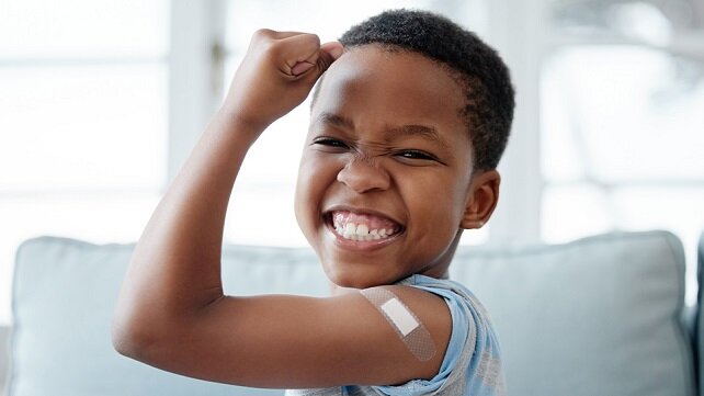 Smiling young boy showing his arm after having received a shot