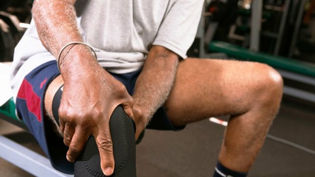 photo of a man holding his knee