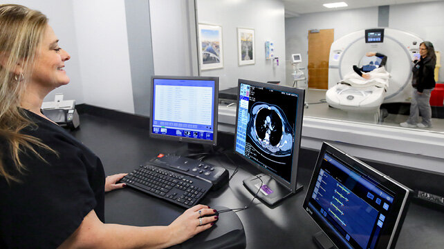 Two clinicians perform a Magnetic Resonance Imaging (MRI) on a patient