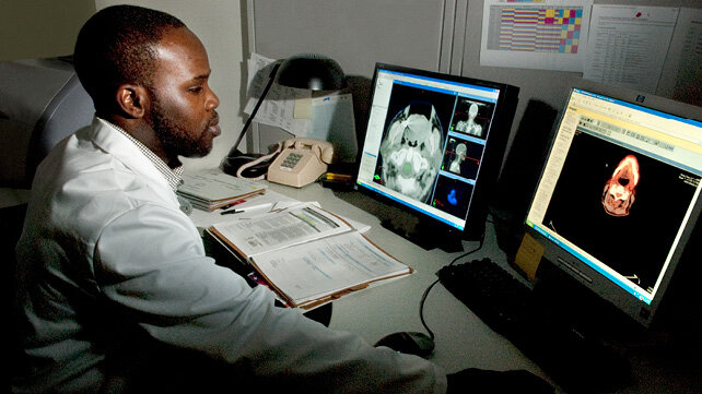 A clinican looks at scans created by Nuclear Medicine Technology (NMT).