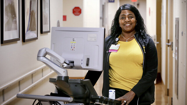 A clinician walks down a hospital hallway.